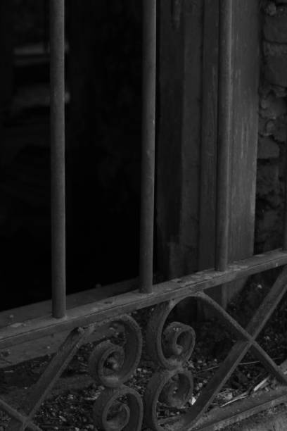 istock OLD HOUSE WINDOW WITH BLACK AND WHITE IRON GRILLE 1218235150
