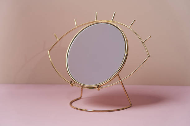 istock Make-up mirror in shape of eye on pastel color background 1218236113