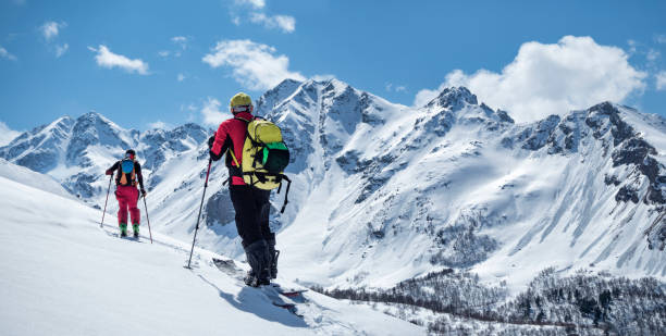 Active men ski touring Two active men ski touring on mountain skis and splitboard at sunny winter day back country skiing photos stock pictures, royalty-free photos & images
