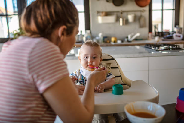istock Mother feeds her baby son 1218238246