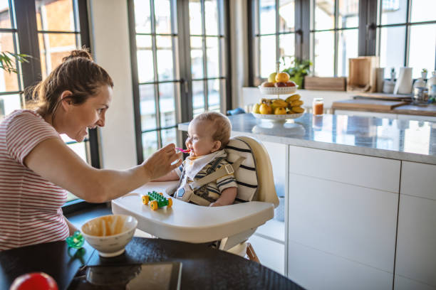 istock Mother feeds her baby son 1218238328