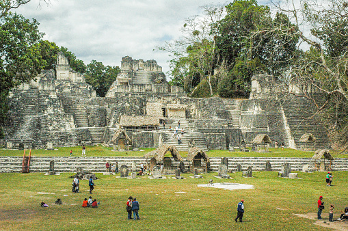 People walking next to the ruins of Tikal National Park an ancient old mayan civilization city in Guatemala.