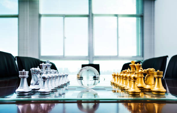 istock Chess pieces and glass earth globe on the conference table 1218241645