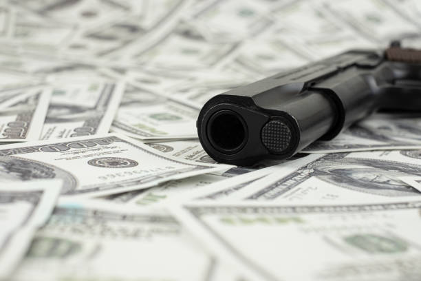 schwarze pistole pistole auf stapel geld 100 dollar hintergrund - guns and money stock-fotos und bilder