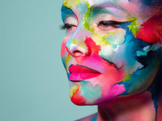 istock Face art and body art. Creative makeup with colorful patterns on the face. Modern makeup art, bold style, 1218243732