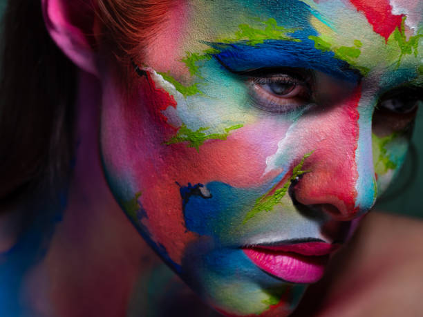 istock Face art and body art. Creative makeup with colorful patterns on the face. Modern makeup art, bold style, 1218243751