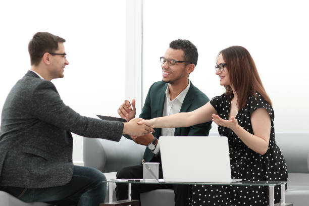 istock business partners shaking hands over the table negotiation 1218245178