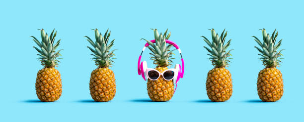 One out unique pineapple wearing headphones One out unique pineapple wearing headphones on a solid color background standing out from the crowd stock pictures, royalty-free photos & images
