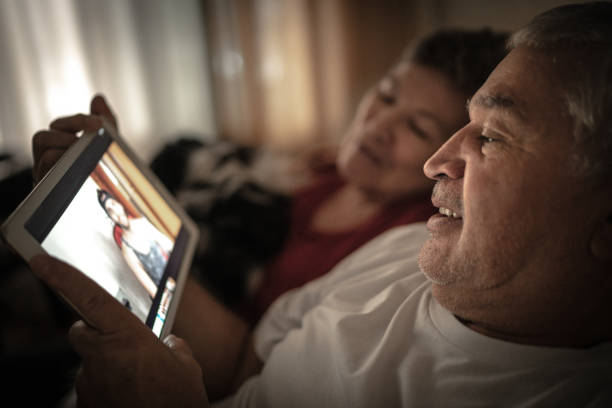 nonni / genitori in una video chat con suo figlio / nipote - grandparent family multi generation family technology foto e immagini stock