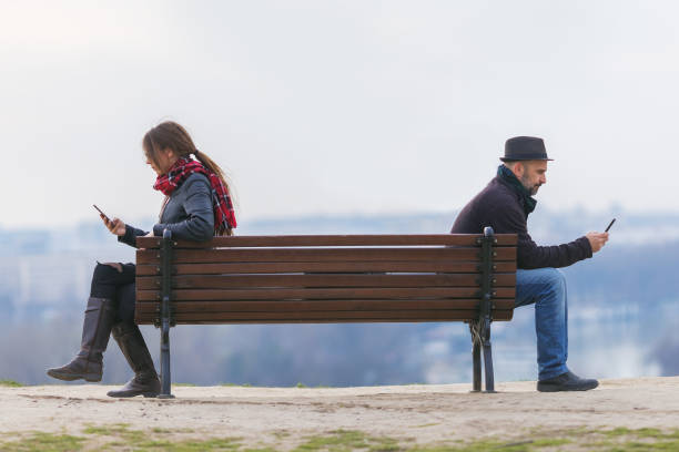 벤치에 떨어져 앉아 있는 남자와 여자 - asocial 뉴스 사진 이미지