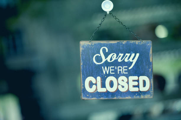 blaues geschlossenes schild im schaufenster eines shops mit der meldung "sorry we are closed" - dauerhafte bewegung stock-fotos und bilder