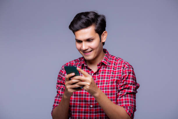 istock Handsome Indian man using mobile phone - stock photo 1218251015