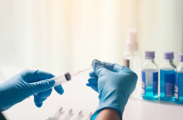 istock Midsection Of Person Holding Syringe 1218252734
