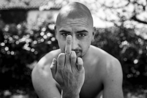 흑백 초상화 의 젊은 성인 남자 보여주는 중간 손가락 음란 한 제스처 에 카메라 - skinhead 뉴스 사진 이미지