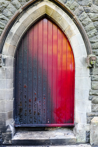 The door of a Roman Catholic Church suffers scorch damage from petrol bombs and paint during a sectarian attack