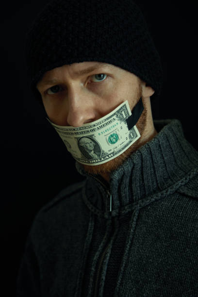 image conceptuelle de corruption et de corruption. silencieux pour de l’argent. verticale de l’homme avec sa bouche fermée avec un billet de banque d’un dollar. - currency silence censorship behavior photos et images de collection