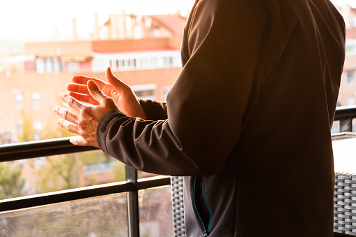 Las manos de un hombre aplaudiendo desde su balcón en España para apoyar al personal médico debido a la pandemia de coronavirus photo