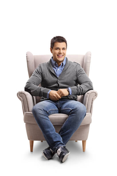 istock Smiling young man sitting in an armchair 1218262849