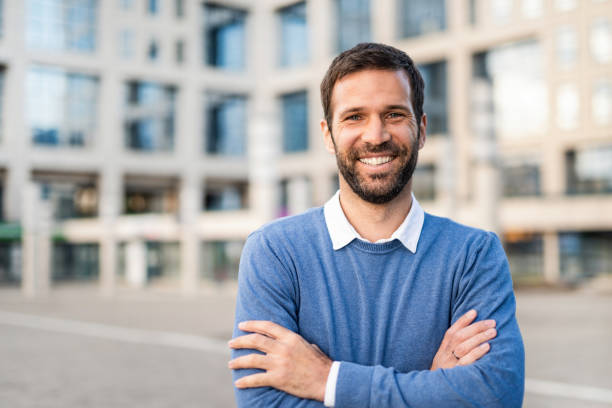 Casual mid adult man looking at camera. Portrait of happy mid adult man living in the city. business person one man only blue standing stock pictures, royalty-free photos & images