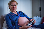 Pregnant woman playing PS4.