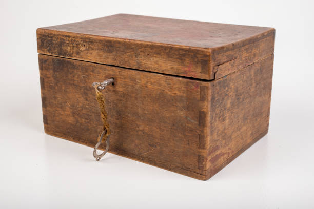 istock Old wooden case and small key. A mysterious wooden container. Light background. 1218267932