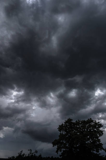 istock Terrible thunderclouds from the side of a plane. Gloomy epic clouds. Background image in a dark gray style. 1218268051