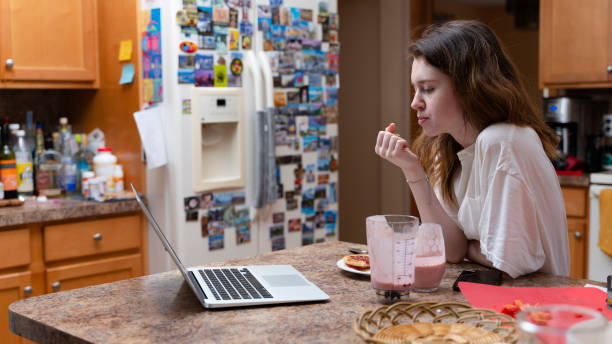 adolescente che usa la conferenza online per incontrare i suoi amici durante la colazione - blueberry smoothie milk shake drink foto e immagini stock