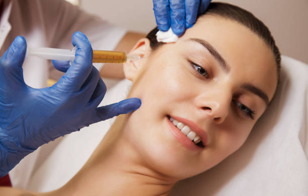 Hand with syringe at the patient cheek