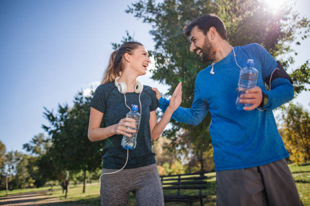 istock Young couple having fun while exercising together at a park 1218274567