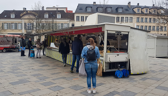 Chartres, France - March 21, 2020: People shopping in a town open food market during the total lockdown due to coronavirus crisis in France.