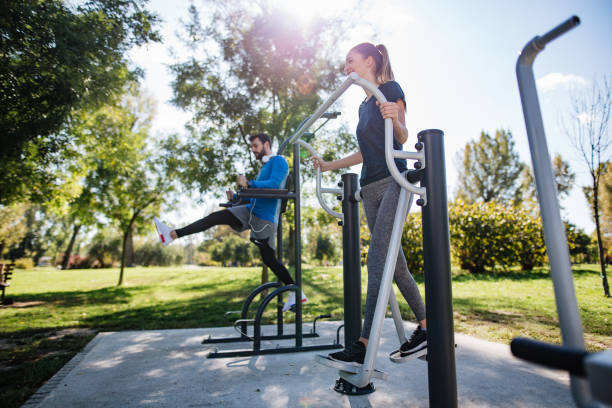 Sports couple exercising in a outdoor gym stock photo