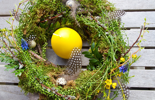 Easter wreath made of natural material, spring flowers and feathers