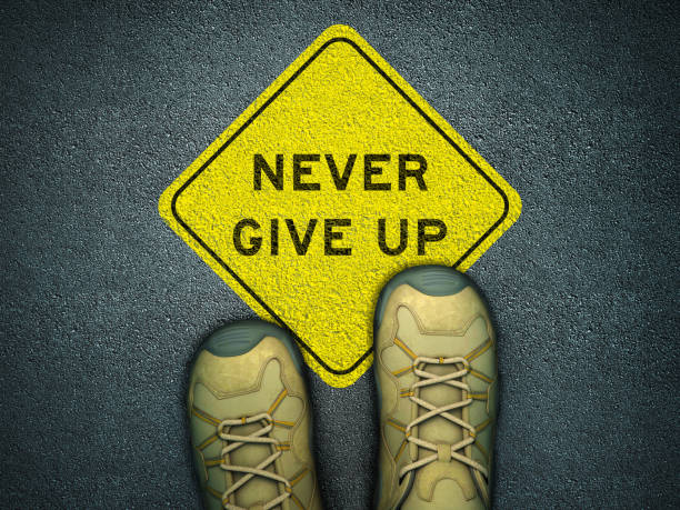 istock Feet on Asphalt with NEVER GIVAP Road sign - 3D Rendering 1218276607
