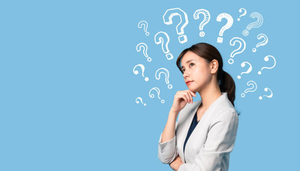 istock Thinking young asian businesswoman with question mark. 1218281867