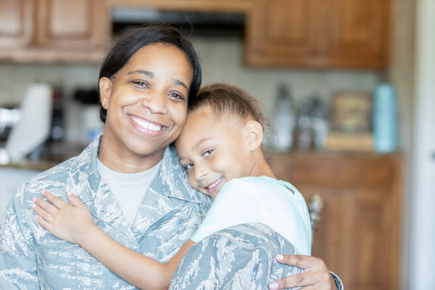 istock Young girl embracing soldier mom 1218283607