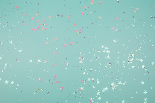 Holographic stars and silver sparkles on blue background. Festive backdrop for your projects.