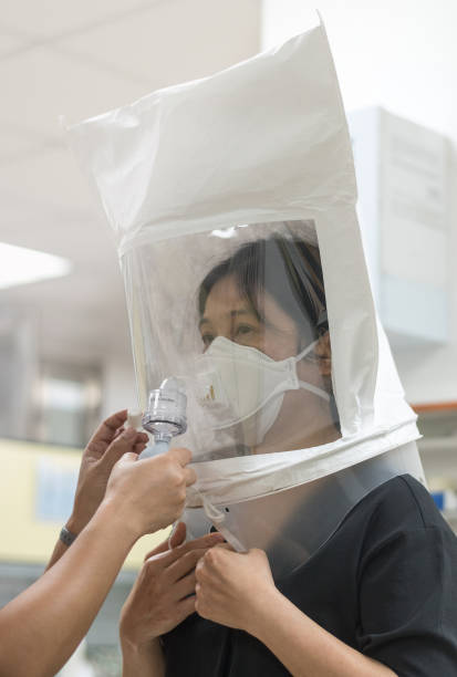 covid-19用に準備されたレスピレーターの適合テスト。n-95外科用マスクで爬虫類システムをテストするアジアの男性は、着用に適切にフィットする顔をチェックします。 - fittest ストックフォトと画像