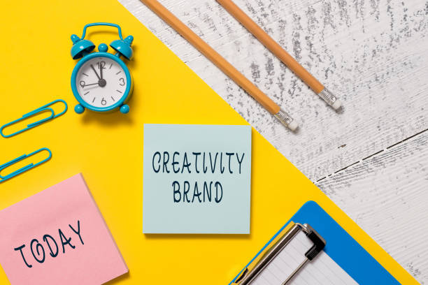 istock Word writing text Creativity Brand. Business concept for design name or feature that distinguishes organization Notepads clips paper sheet clipboard markers alarm clock wooden background. 1218284780