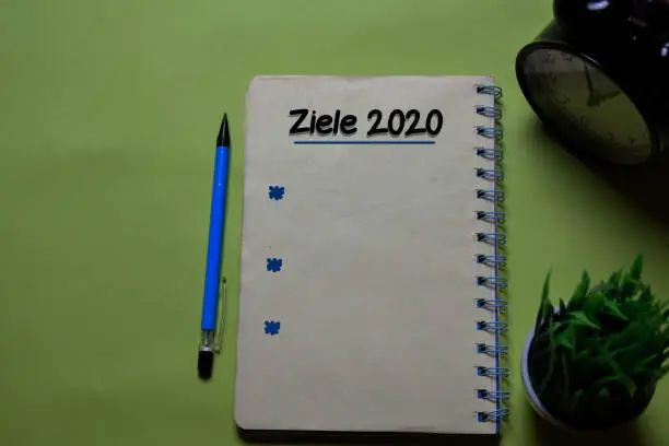 Photo of Ziele 2020 write on a book isolated on office desk. German Language it means Goals