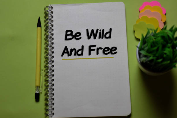istock Be Wild and Free write on a book isolated on office desk. 1218289353