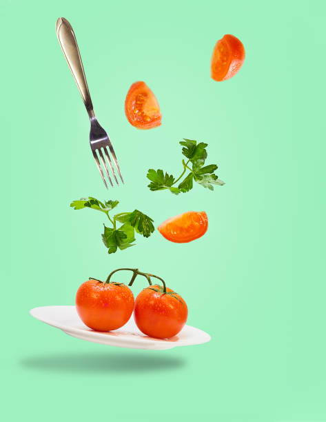istock tomato on the plate flying fork and parsley vegetable dieting 1218290850