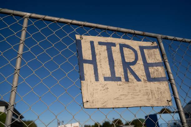 'Hire' sign on  fence with blue sky.