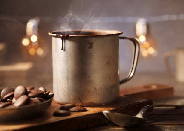 Homemade spicy hot chocolate in an old metal mug with chocolate pastilles.