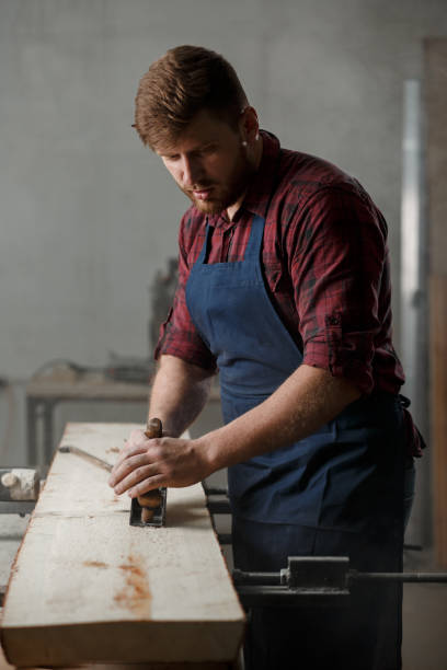 istock The master carpenter works with the tree in the workshop. Small business 1218293155