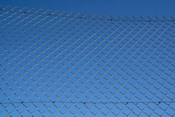 istock Steel mesh wire fence with blue sky under blue sky. 1218293207