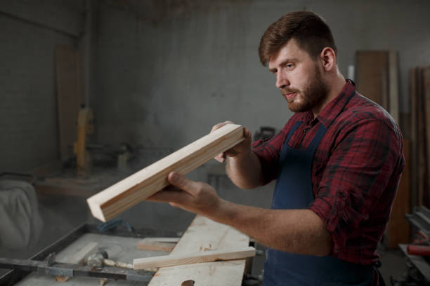 istock The master carpenter works with the tree in the workshop. Small business 1218293224
