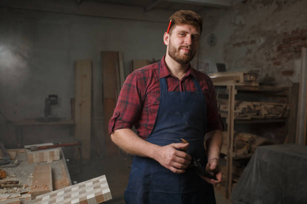 istock The master carpenter works with the tree in the workshop. Small business 1218294061