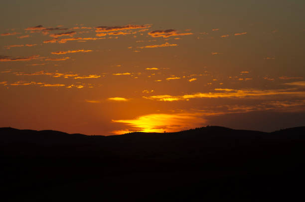 Warm sunset light over rolling farmland and hills in northern Greece, creating a calm rural atmosphere near Mount Olympus.