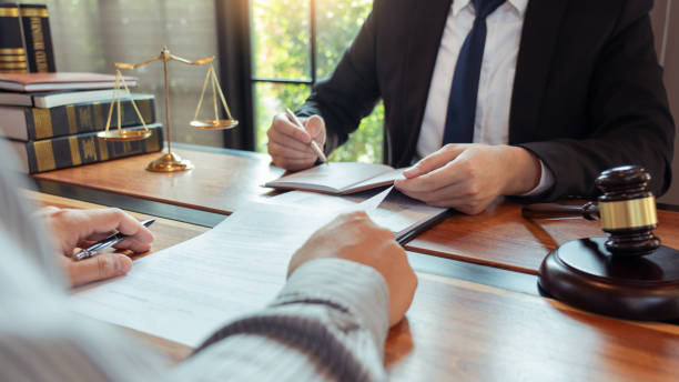 istock Lawyer working with client discussing contract papers with brass scale about legal legislation in courtroom, consulting to help their customer 1218301330