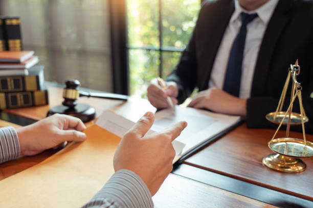 istock Lawyer working with client discussing contract papers with brass scale about legal legislation in courtroom, consulting to help their customer 1218301461